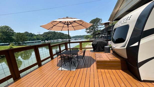 Une terrasse avec une table et des chaises, un barbecue abrité, et un bateau nommé « Future Rockwood » sur la droite.