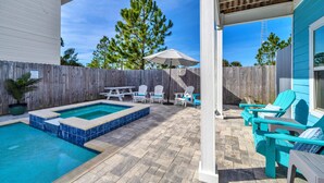 A backyard with a swimming pool, patio furniture, and a wooden fence. - The Blue Escape- 5BR/2.5BA, Huge Private Pool and Hot Tub. Steps to the Beach (Panama City)