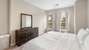 A bedroom with a large bed, a dresser with a mirror, and a window with curtains. - Beautiful 2 Bedroom Home Near Old Town Spring (Humble)