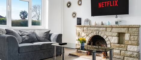 Télévision, cheminée, table de tennis de table, livres