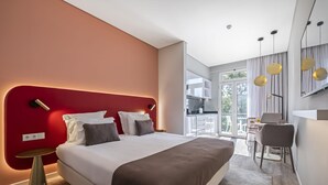 Ein modernes Hotelzimmer mit einem großen Bett, einem Schreibtisch und einem Balkon.