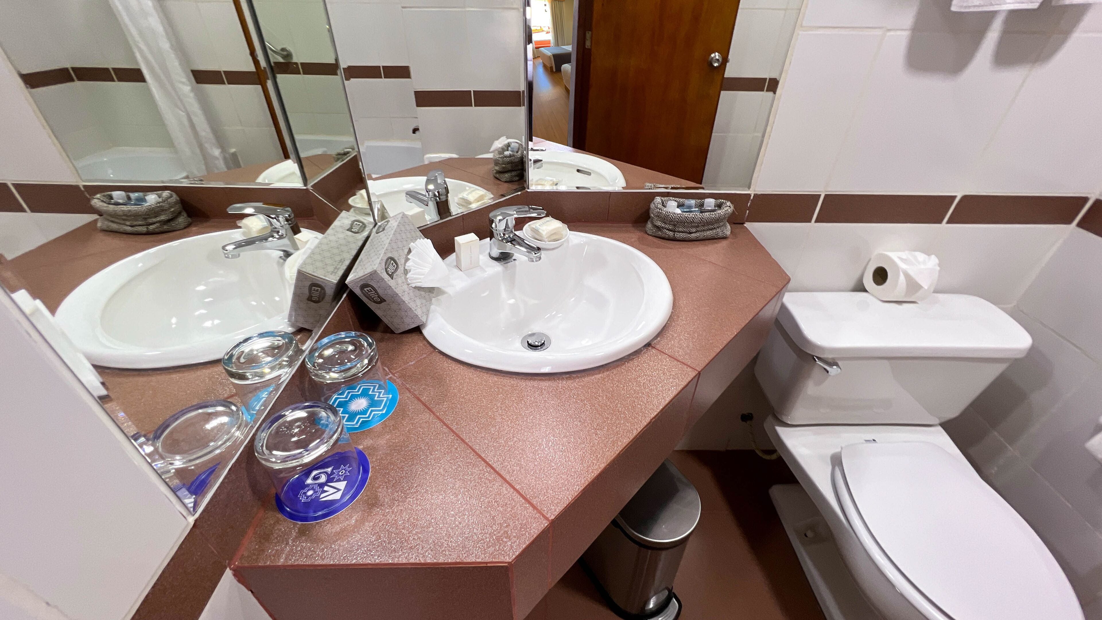 Un baño con dos lavamanos, un inodoro y una ducha.