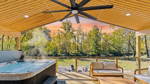 A hot tub, outdoor seating, and a view of trees. - The River Nest-Hot Tub & River View (Fountain Lake)