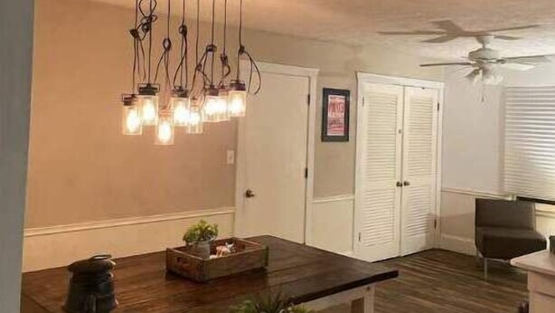 A modern kitchen with a wooden countertop, hanging pendant lights, and a ceiling fan. - Three Kings Ranch (Indianapolis)