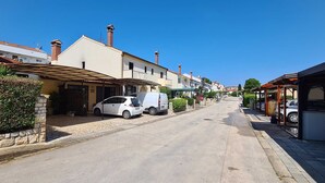 A residential street with houses, parked cars, and a clear blue sky. - SUNNY Studio Apartment (Rovinj)