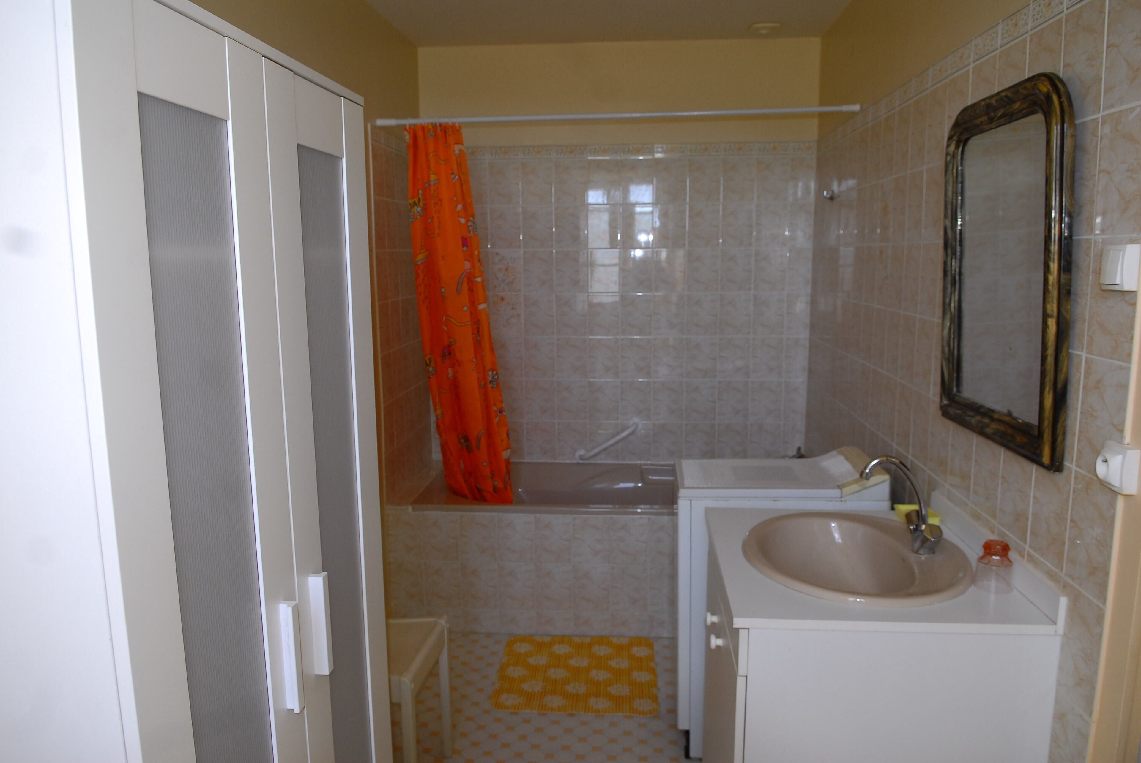 Ein Badezimmer mit einer Badewanne, einem Waschbecken und einem Spiegel.