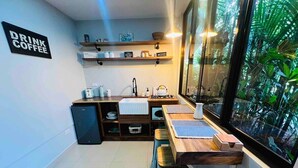 A compact kitchen with a built-in stove, a sink, and a window overlooking a lush green area. - Cabin in La Fortuna with Jacuzzi and Pool (La Fortuna)