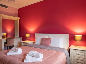 Cozy retreat with a vibrant wall, a comfortable bed, and a desk for work or reading.