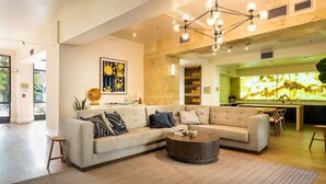 A spacious living area with a large sectional sofa, a round coffee table, and a modern chandelier. - Luxury Resort Condo by Six Flags Magic Mountain

 (Santa Clarita)