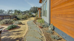 Un sendero conduce a una casa de madera con jardín.
