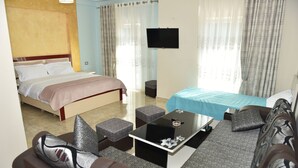 Een hotelkamer met een bed, een bank, een salontafel en een televisie.
