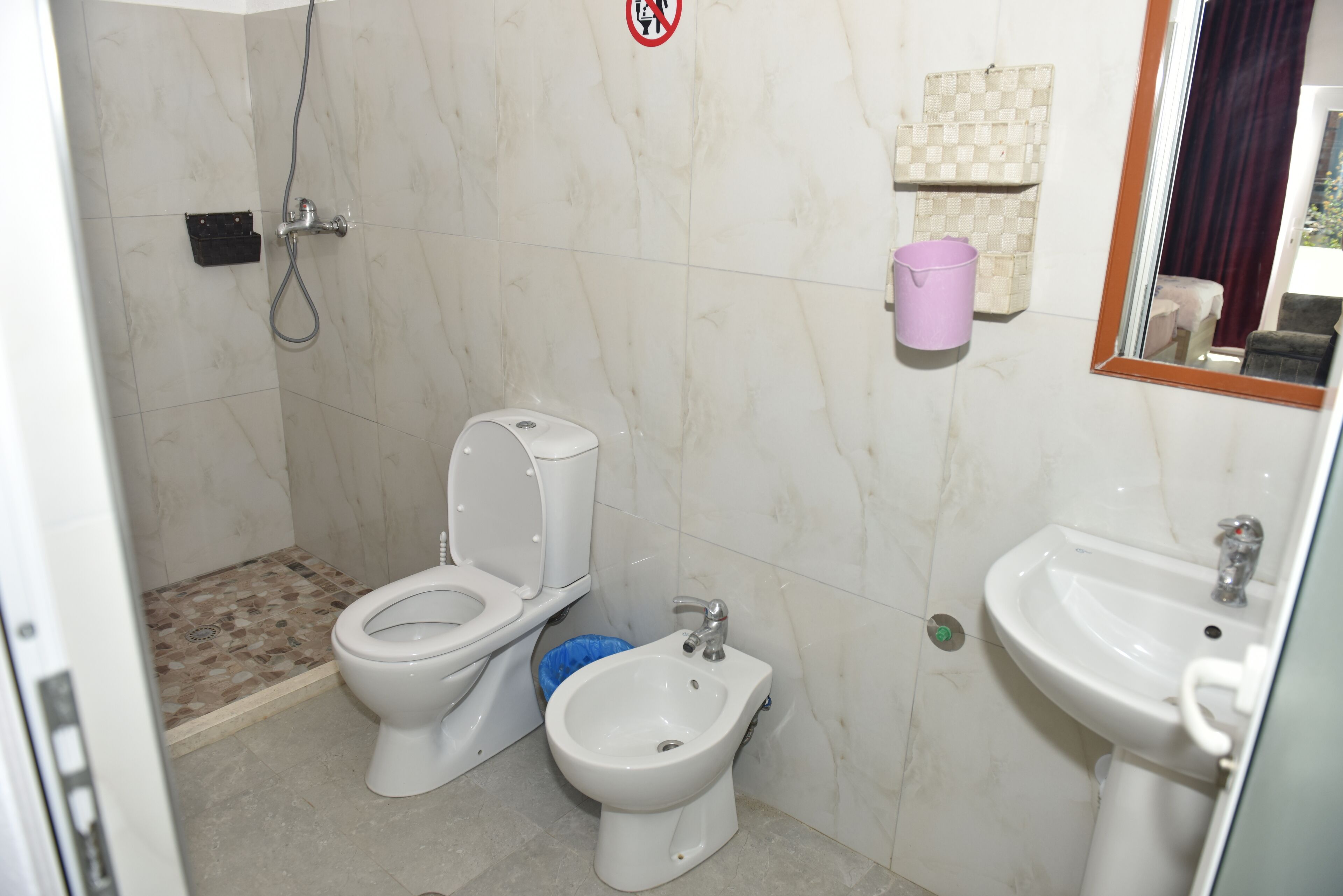 Ein Badezimmer mit Toilette, Bidet, Waschbecken und Dusche.