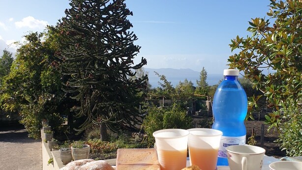 Taula amb pastissos, Nutella i begudes, amb un paisatge idíl·lic de paisatge i muntanyes.