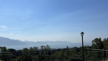 Terraço no telhado com vista para montanhas distantes e céu claro.