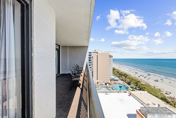 A balcony with a view of a beach and a pool. - Family Oceanfront Condo Located in North end of Myrtle Beach! (Myrtle Beach)