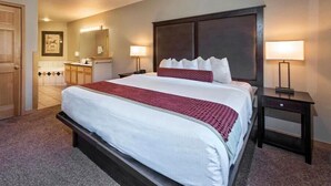 A hotel room with a large bed, a dresser, a mirror, and two bedside lamps. - One-Bedroom Residence (Breckenridge)