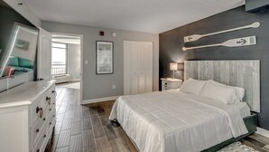 A bedroom with a bed, dresser, and a large mirror.