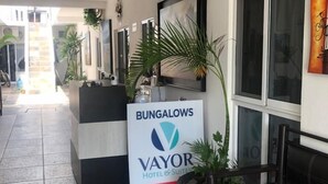 Un área de recepción con un cartel que dice 'BUNGALOWS VAYOR HOTEL & SUITES'.