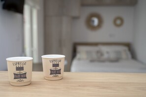 Cups of espresso are served in this cozy space, where a comfortable bed and decorative accents await.