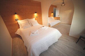 Un dormitorio con cabecera de madera, dos camas, un espejo y una lámpara colgante.
