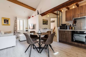 Eine moderne Küche mit Holzausstattung, Backofen und einem Essbereich mit rundem Tisch und Stühlen.