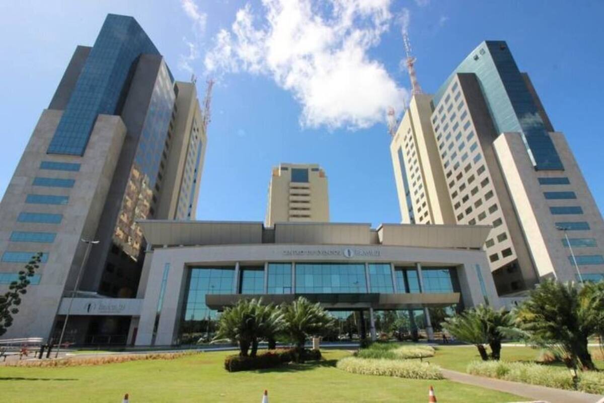 A modern building with a central entrance and two tall towers on either side.