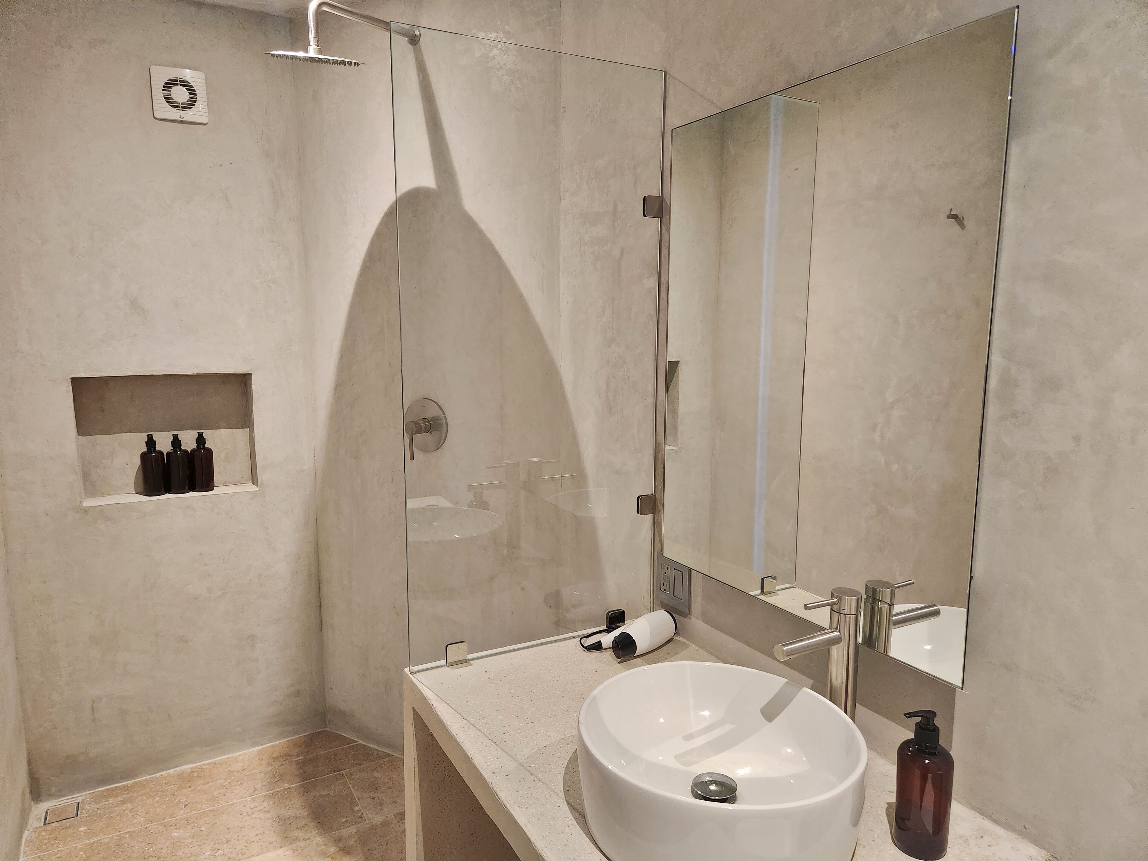 Een moderne badkamer met een grote spiegel, een wastafel en een douche.