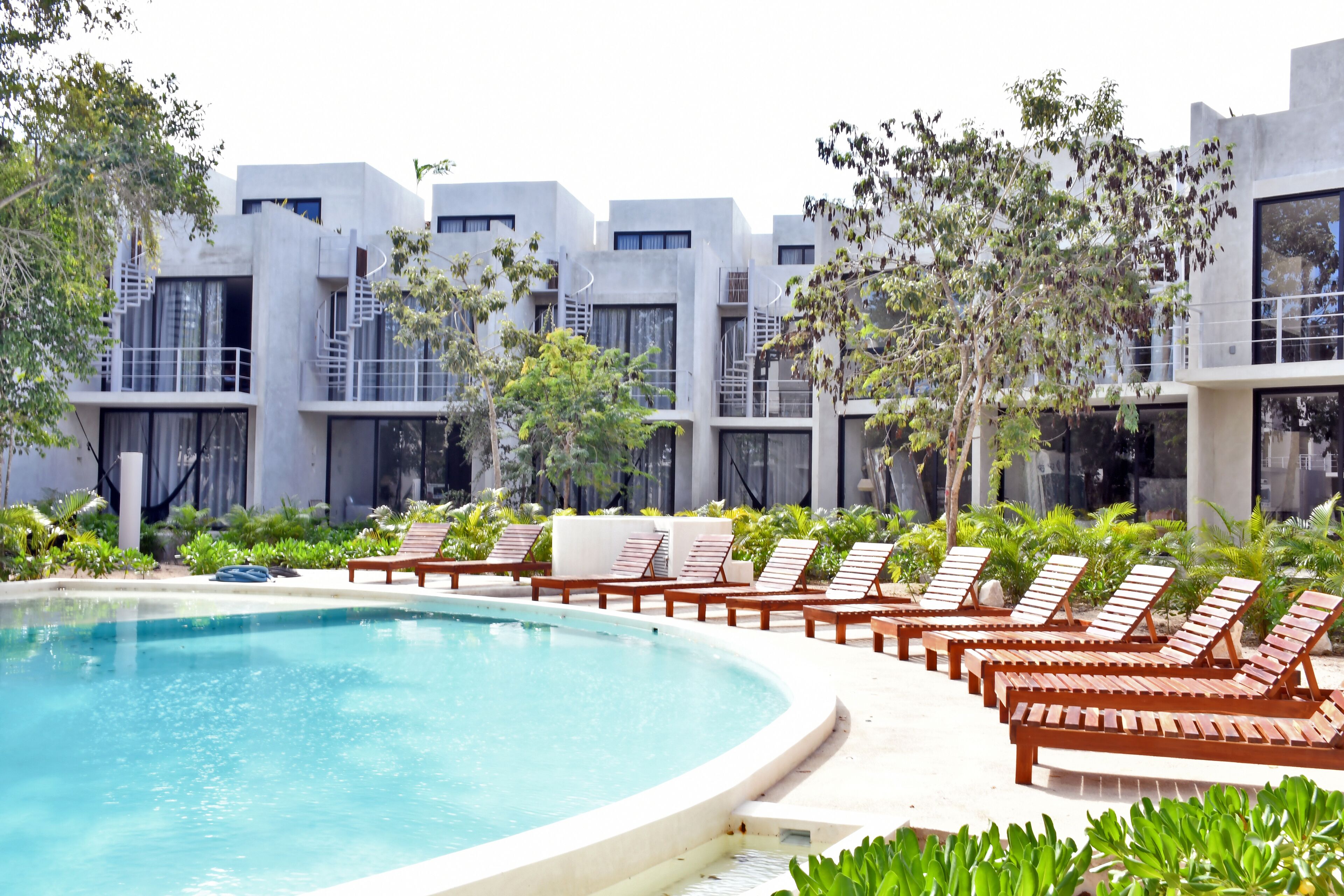 Una piscina al aire libre, sillones reclinables de piscina