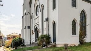 Eine Kirche mit einem markanten Turm und Rundbogenfenstern.