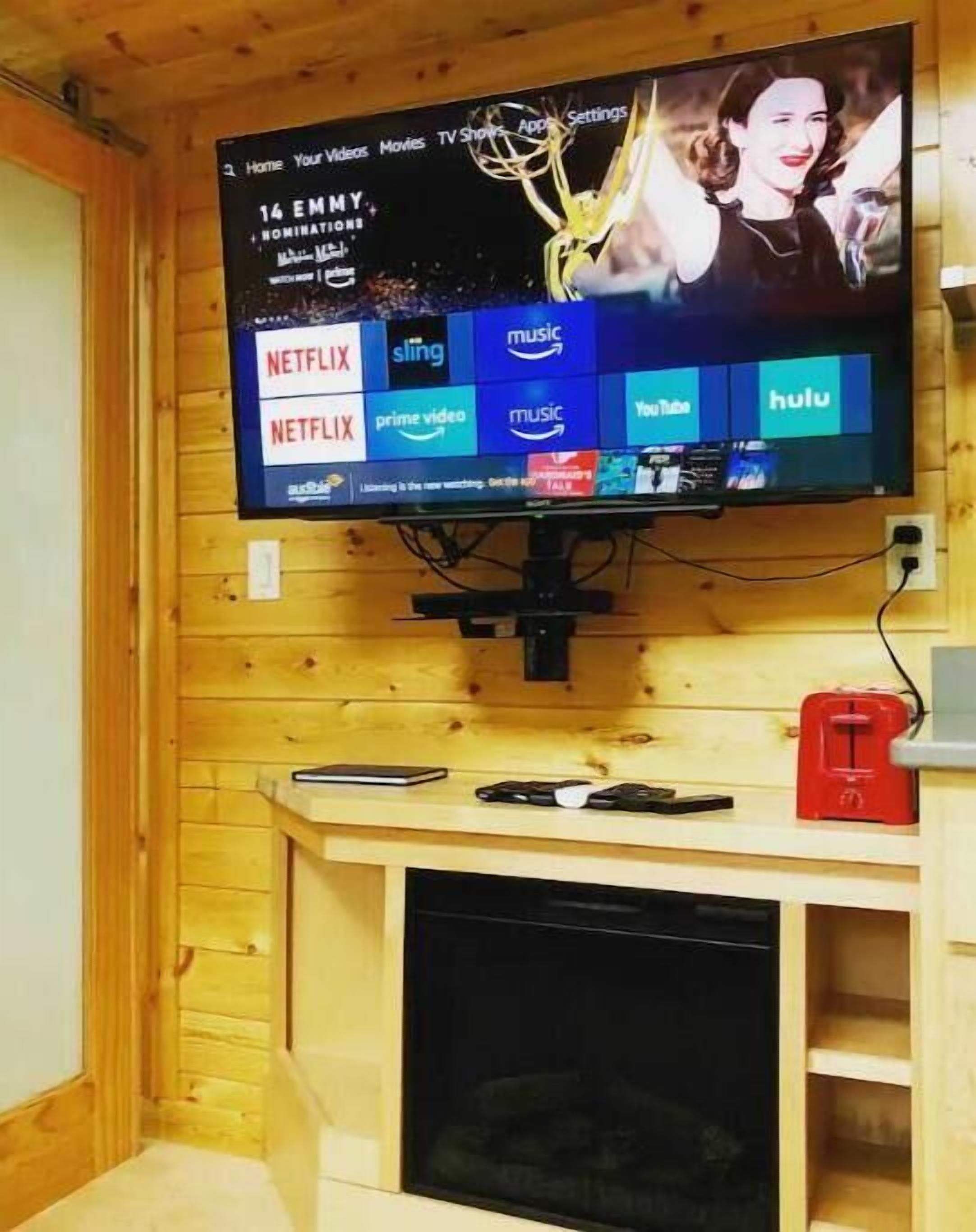 En tv-skärm som är monterad på en vägg av trä och som visar olika streamingtjänster.