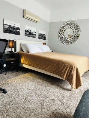 A bedroom with a bed, a nightstand, a lamp, and wall-mounted pictures. - Midtown 2-Bedroom Flat: Steps to Ice Blocks (Sacramento)