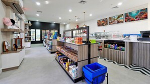 A grocery store with shelves stocked with various products, a checkout counter, and a blue shopping basket. - Spacious 5 Bedroom Villa w/ Themed Bedrooms, Theater Room, and Free Pool Heat (Kissimmee)