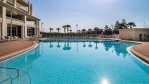 A clear blue pool with lounge chairs and a building in the background. - Ariel Dunes I Unit 1304 at Seascape for 7 people (Miramar Beach)