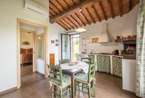A kitchen with wooden cabinets, a dining table with chairs, and a window.