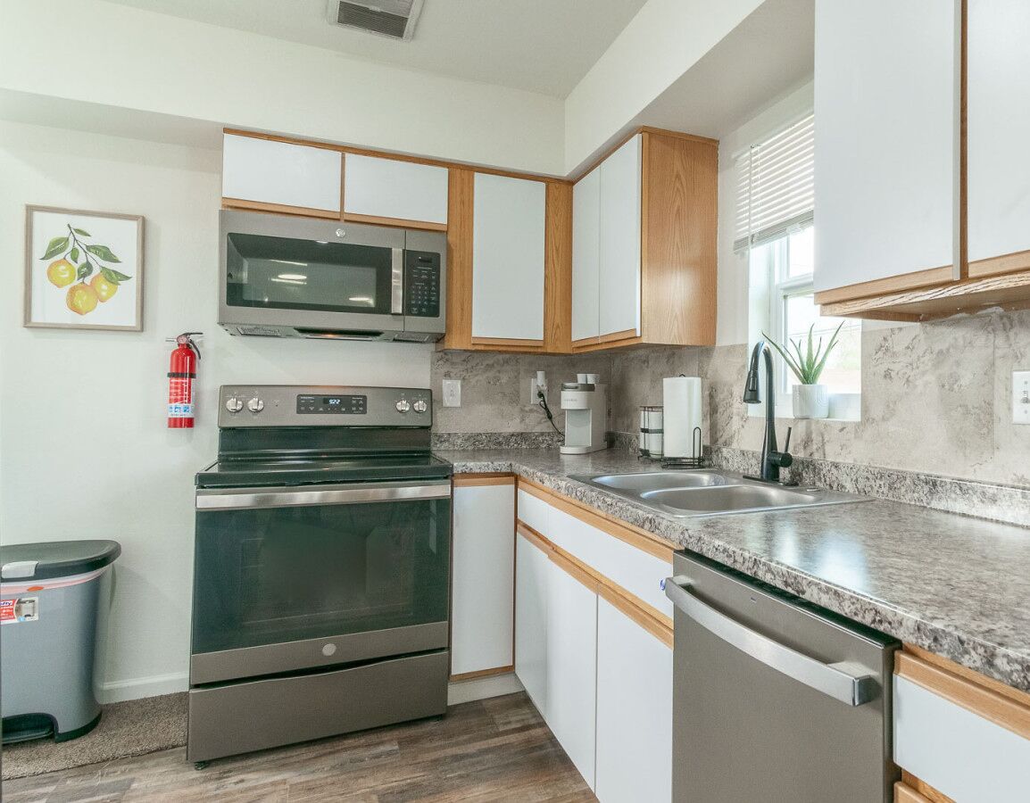A modern kitchen with a built-in oven, microwave, and dishwasher.