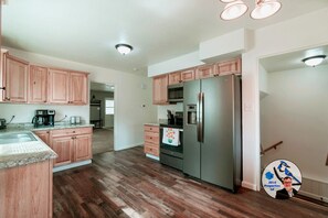 A kitchen with wooden cabinets, stainless steel appliances, and a granite countertop.