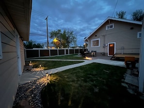 A backyard with a lawn, a fire pit, and a patio area with outdoor furniture. - Dragonfly House: A cheerful five-bedroom (Great Falls)