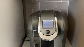 Eine Kaffeemaschine mit digitaler Anzeige, einer Bedienknop und einem Wasserbehälter.
