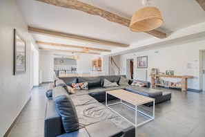 A modern living room with a sectional sofa, a coffee table, and a bookshelf.