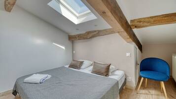 Ein Schlafzimmer mit Oberlicht, einem Bett, einem Sessel und einer Heizung.