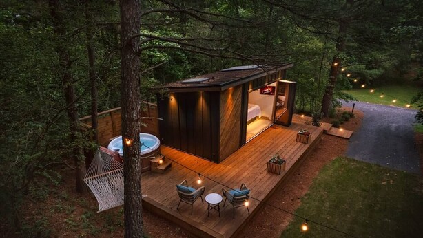 Uma cabana com hidromassagem, área de estar no deck e um pequeno espaço ao ar livre.
