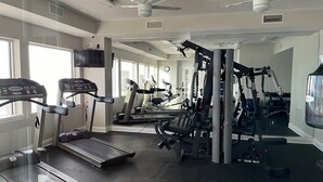 A gym with treadmills, weight machines, and ceiling fans. - Life is better at the beach!  Stunning, oceanfront, corner-unit condominium. (Daytona Beach Shores)