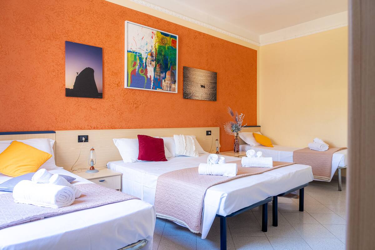 Une chambre d’hôtel avec deux lits, une table de chevet et des œuvres d’art accrochées aux murs.