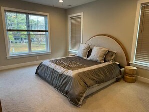 A bedroom with a large bed, two windows with blinds, and a view of the outdoors. - Bethany Beach-1.2 miles from boardwalk-large families welcome-community pool (Ocean View)