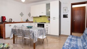 Un espace de vie compact comprenant un coin repas, une kitchenette et un canapé.
