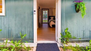 A doorway leading into a room with a bed, a hanging plant, and a framed picture on the wall. - Boho Vibe House with Pool near Hollywood (Los Angeles)