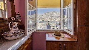 A kitchen with a view of boats and a mountain. - 2islands Waterfront House (Symi)