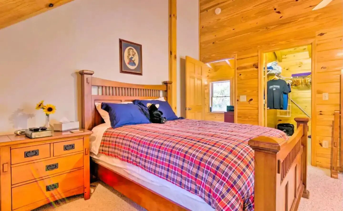 A wooden bedroom with a bed, nightstand, and dresser.