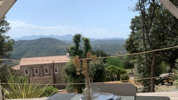 A table set outdoors with a view of mountains and a building in the background.