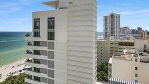 A modern hotel with a white facade, multiple balconies, and a view of the beach and ocean. - FontaineBleau Resort Ocean plus Bay View w/ Balcony (Miami Beach)